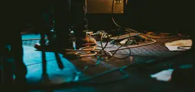 Pés num palco com cabos espalhados pelo chão